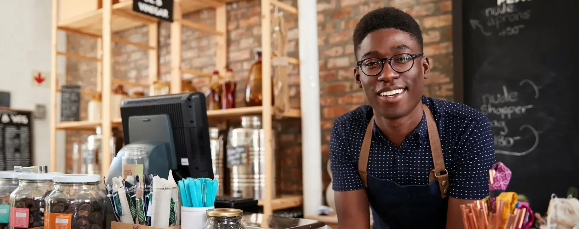 Student achter toonbank in koffiezaak