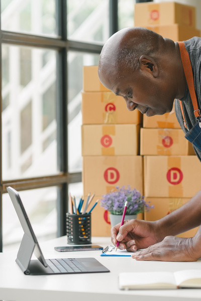 Man controleert orders in dozen op kantoor. 