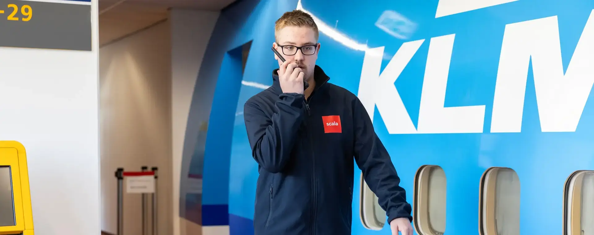 Student beveiliger met walkie talkie bij vliegtuig