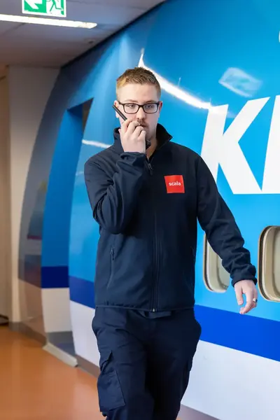 Student beveiliger met walkie talkie bij vliegtuig