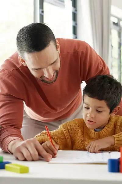 Leerkracht helpt kind met tekenen in klaslokaal