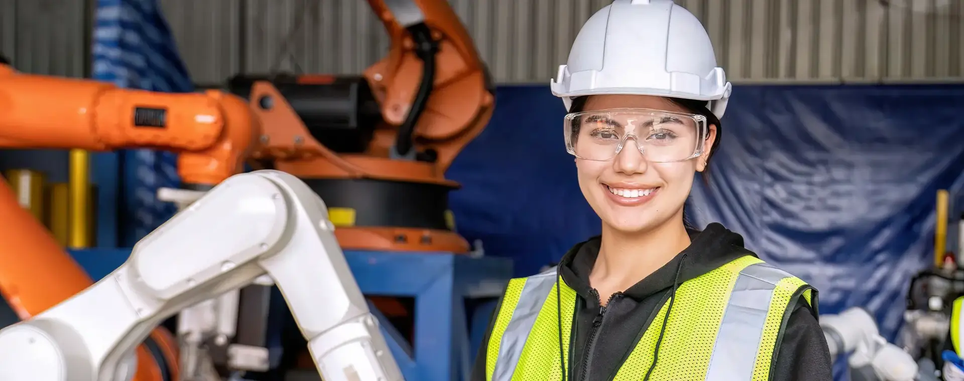 Studente met helm en afstandsbediening voor robotarm