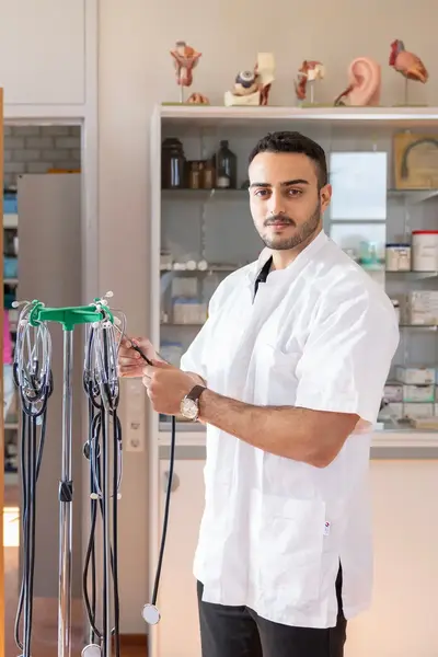 Dokter in spreekkamer naast medische apparatuur