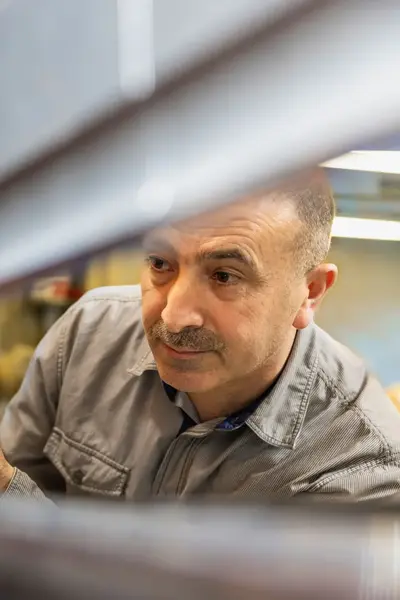 Man plaatst onderdeel in machine