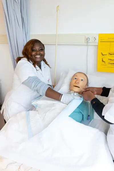 Verpleegster in opleiding bij ziekenhuisbed