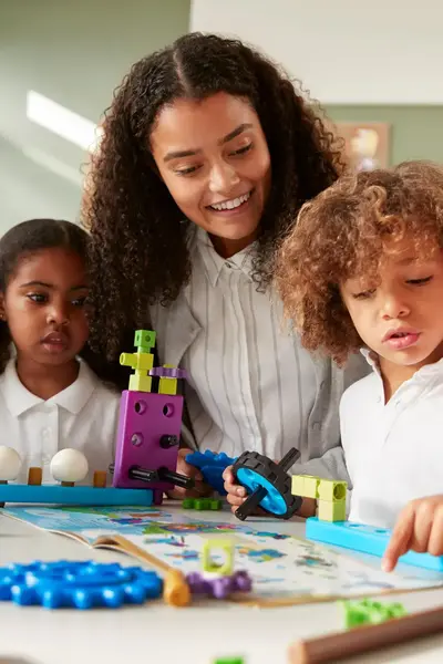 Een jonge docent begeleidt een groep kleuters die samen spelen en leren.