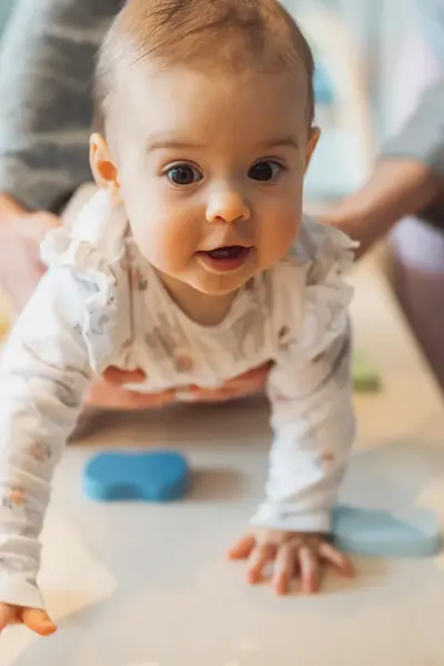 Baby kruipt over een kleedje op de grond