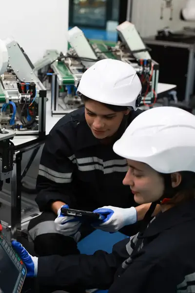 studenten mechatronica inspecteren een robotarm
