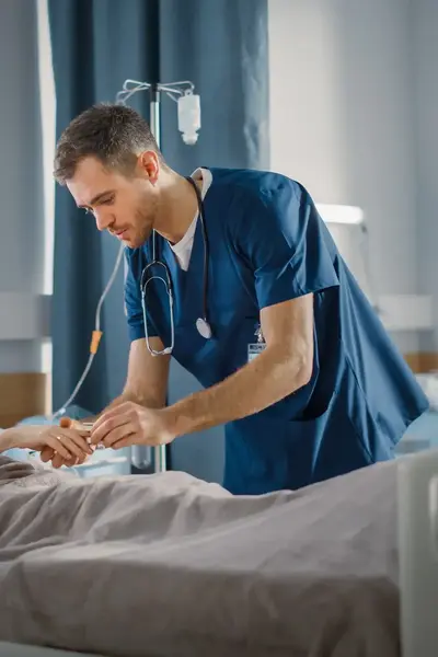 Verpleger controleert patiënt in ziekenhuisbed