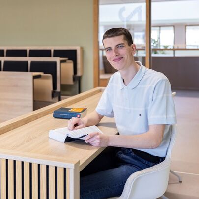 Rechtenstudent bestudeert wetboek in collegezaal
