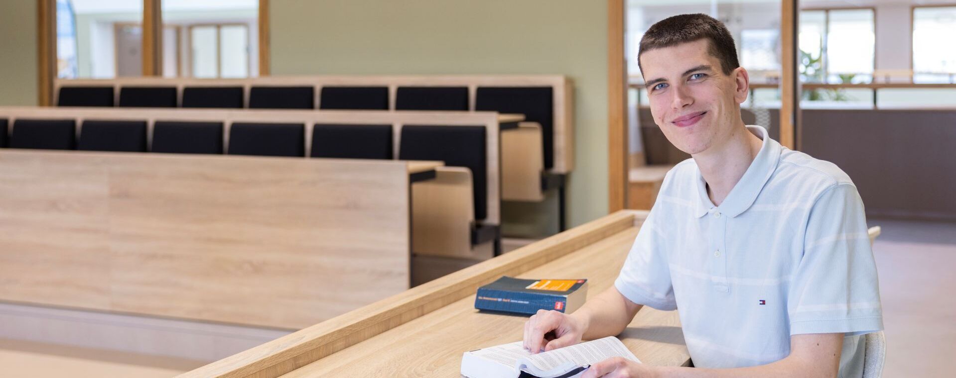 Rechtenstudent bestudeert wetboek in collegezaal