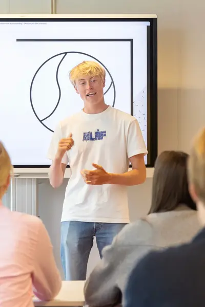 Student in wit T-shirt geeft presentatie in klas