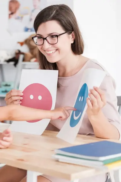 Assistent met kind die lachend gezicht aanwijst op A4