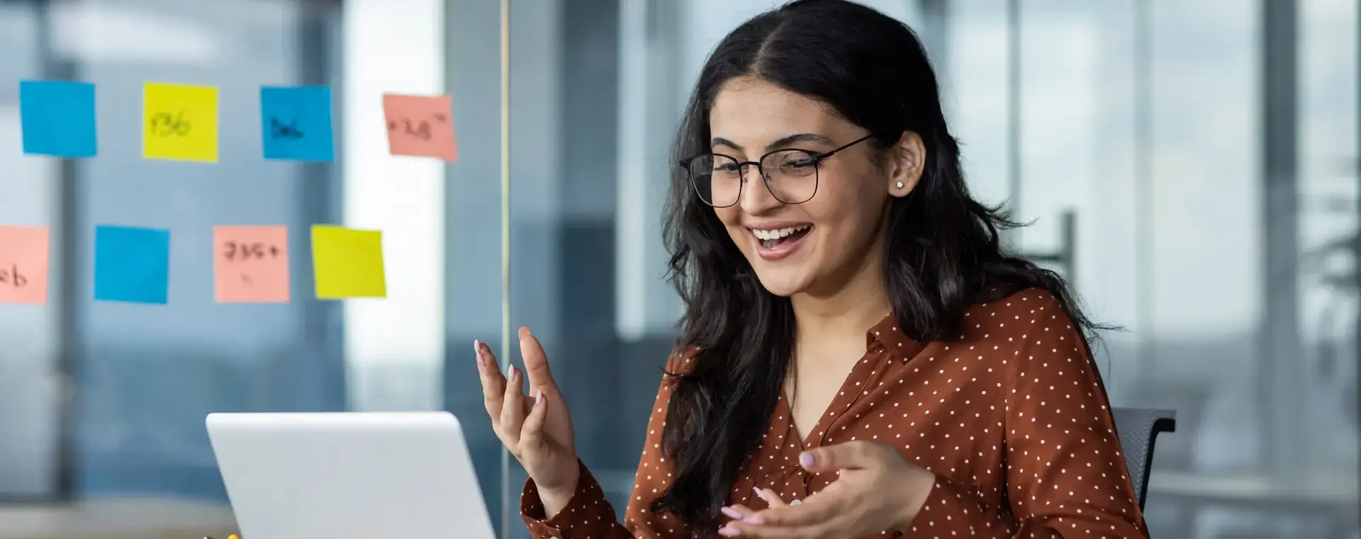Lachende dame achter laptop in kantoorsetting