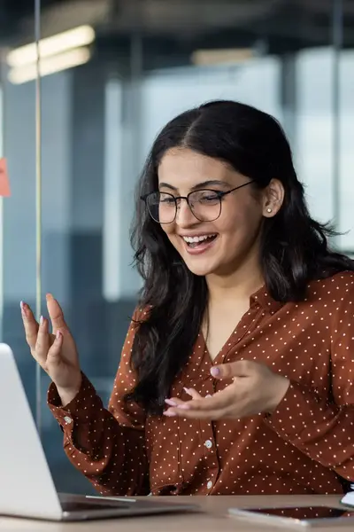 Lachende dame achter laptop in kantoorsetting