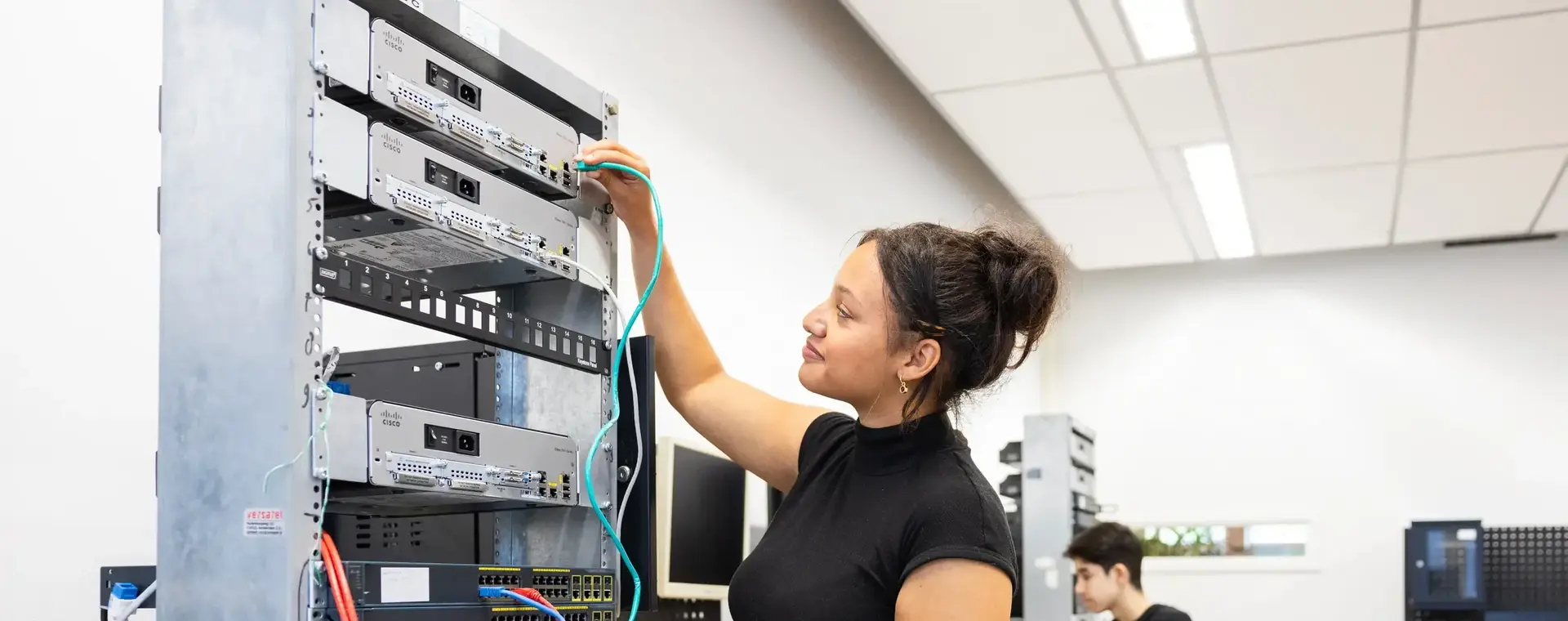 Student sleutelt aan bekabeling computers