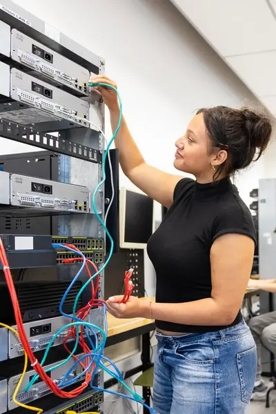 Student sleutelt aan bekabeling computers