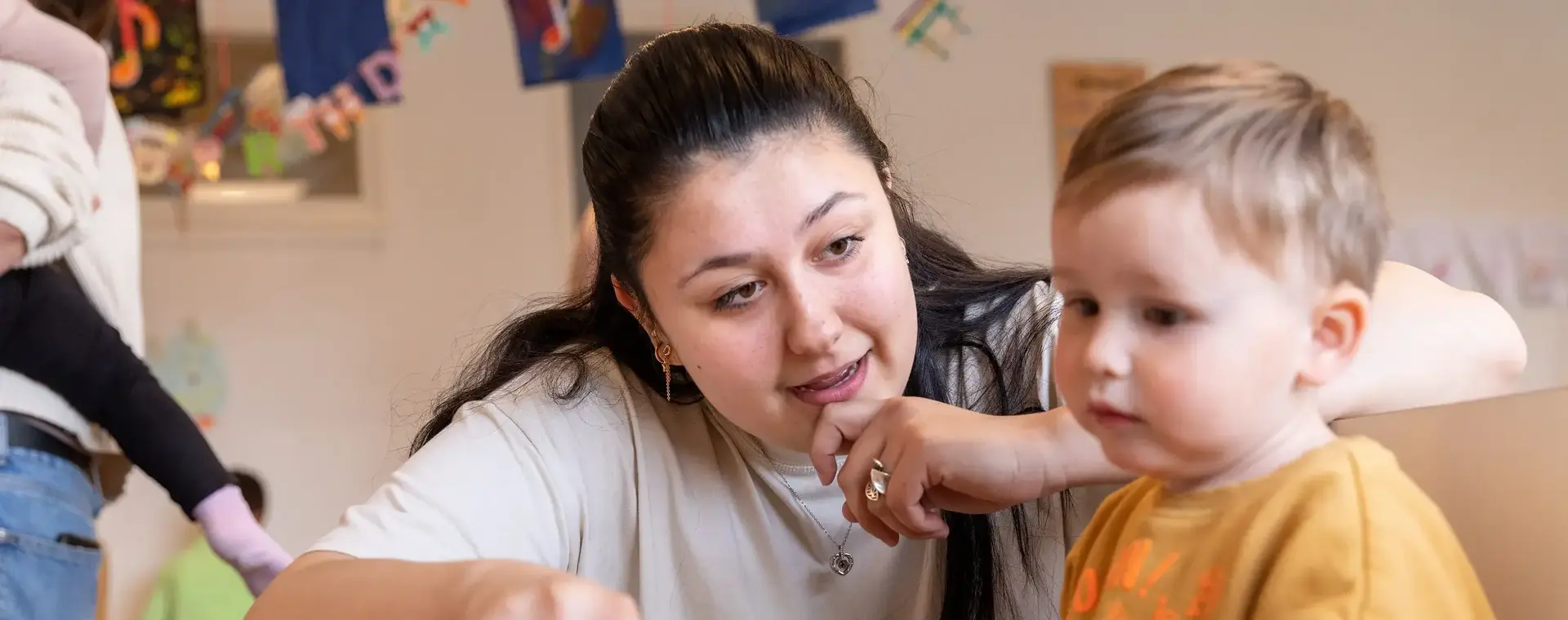 Medewerker kinderopvang met jongetje
