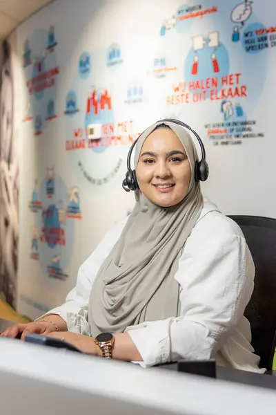 Receptioniste achter een balie met headset