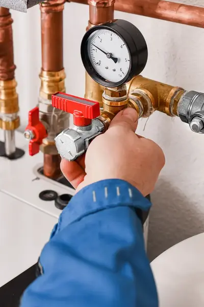 Twee handen met waterpomptang die werken aan leidingen