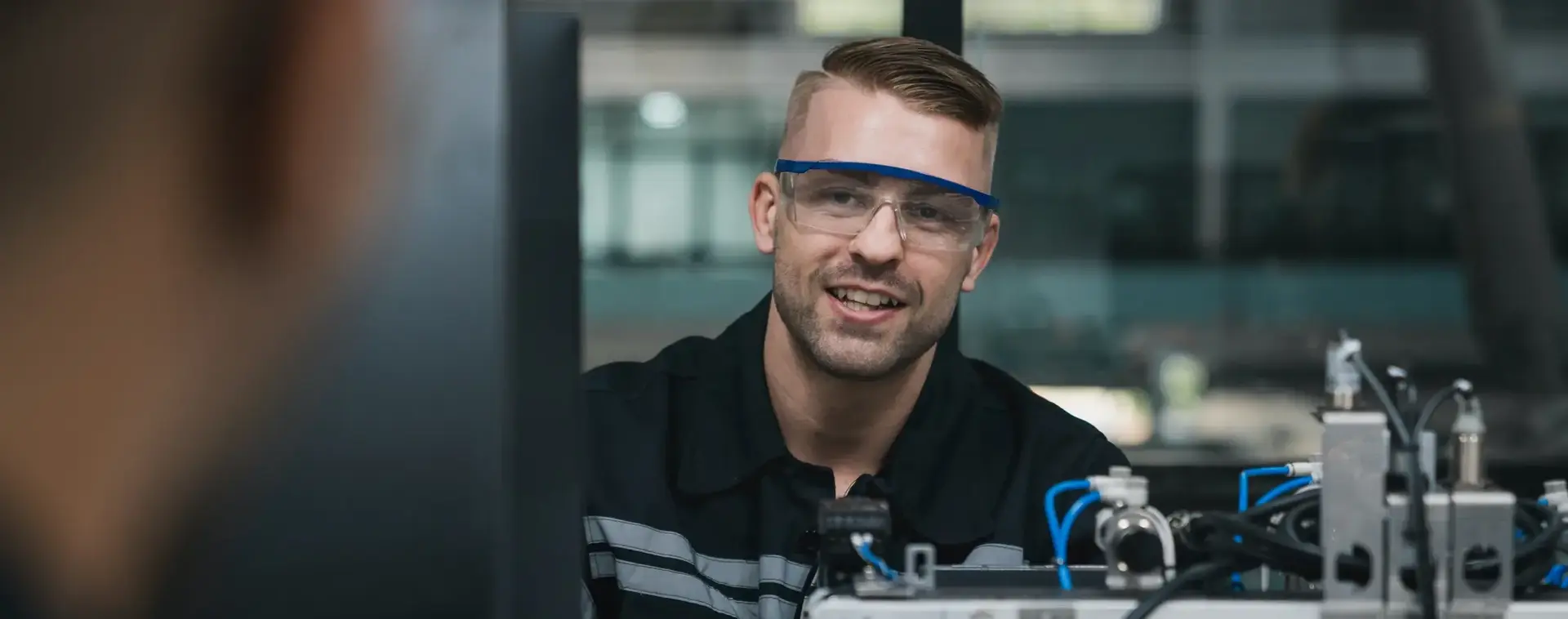 Man met werkbril en blauwe overall controleert apparatuur