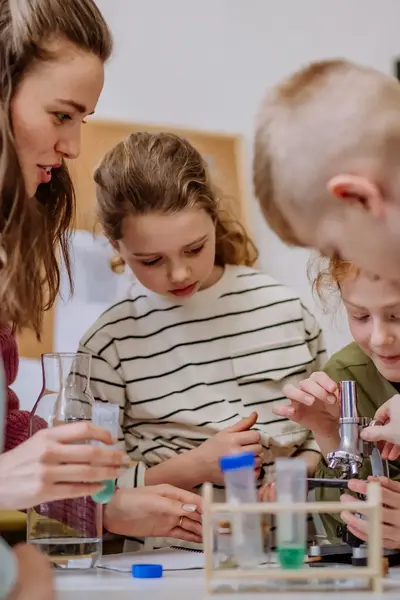 Kinderen bezig met een microscoop.