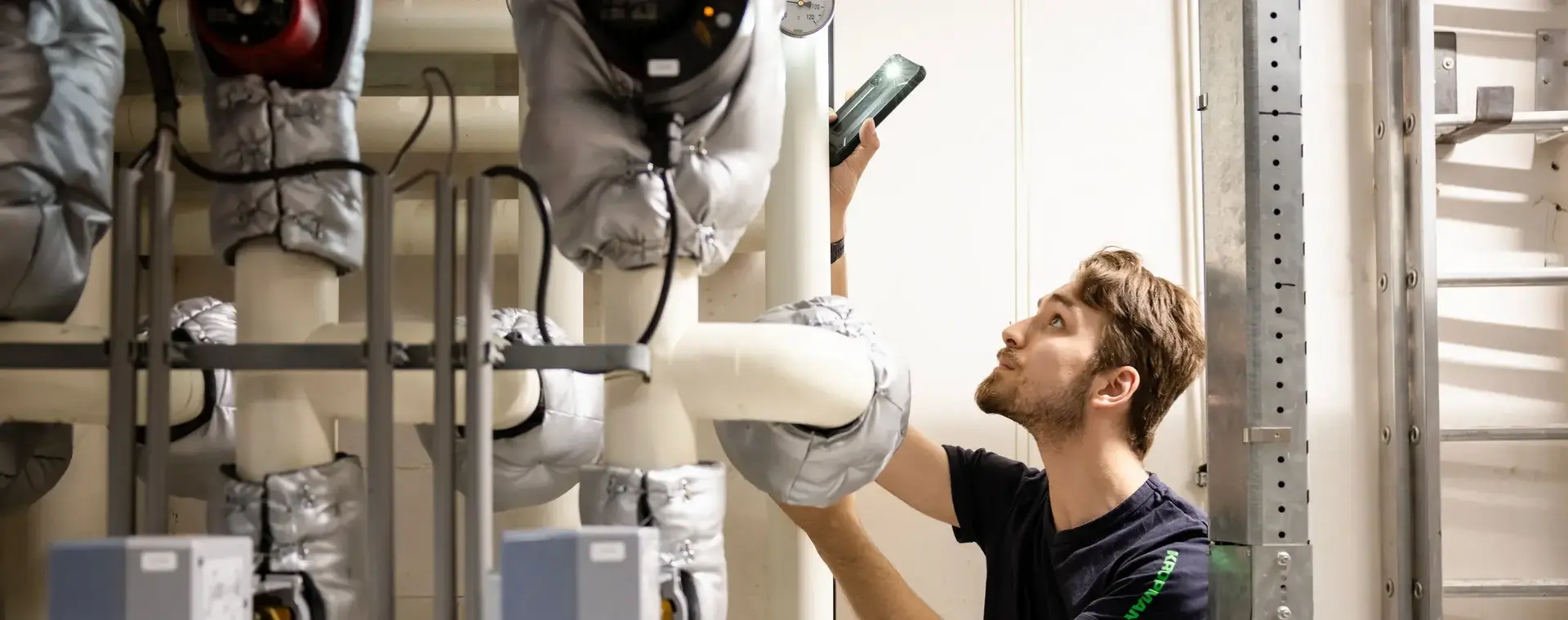 Monteur inspecteert isolatiebuizen en meet installatie.