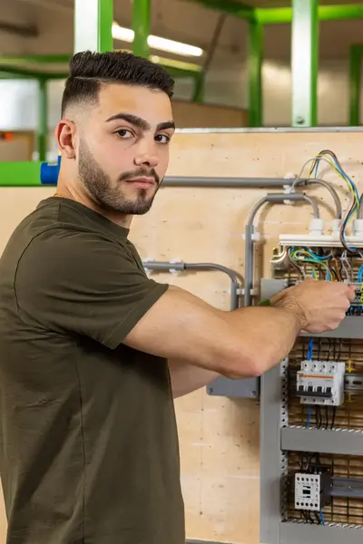 Jongeman repareert een elektrapaneel