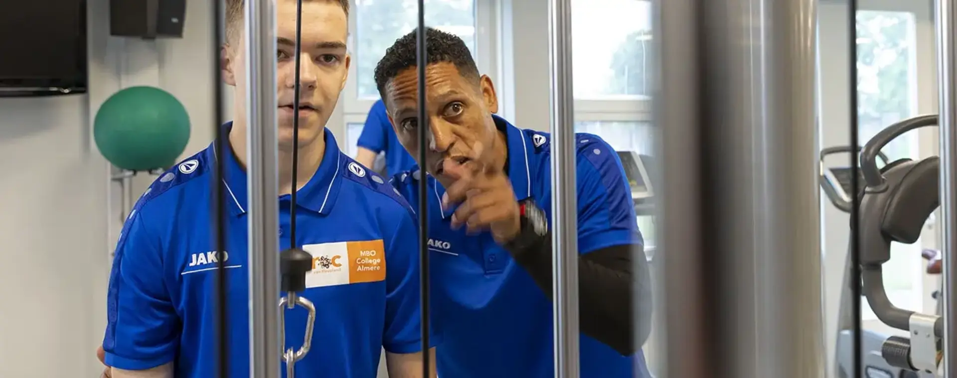 Coach geeft aanwijzingen aan gewichtheffer