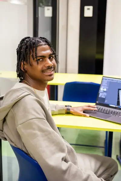 Student achter laptop in leslokaal