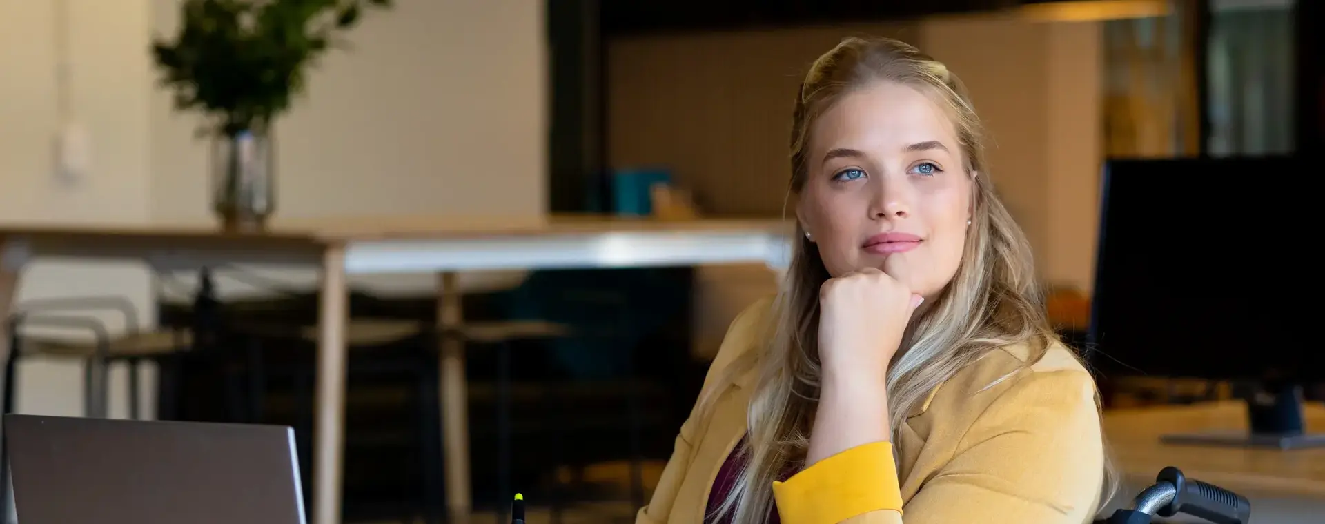 Student achter laptop met koffie en pennenbak