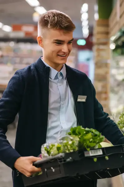 Winkelier vult schappen supermarkt met groenten