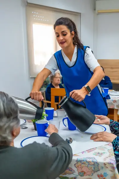 Vrouw schenkt koffie in aan tafel met oudere dames