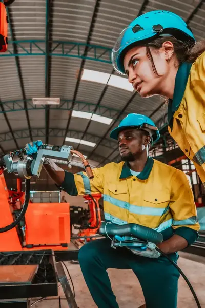 Reparateurs bekijken en werken aan oranje machine