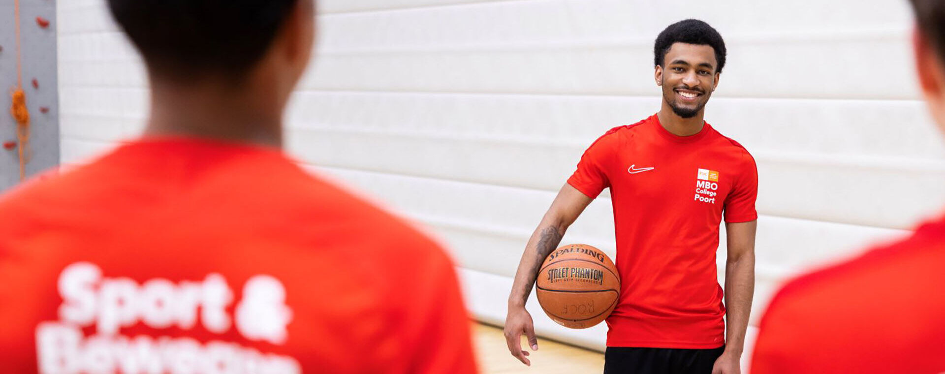 Studenten in sporttenue spelen basketbal