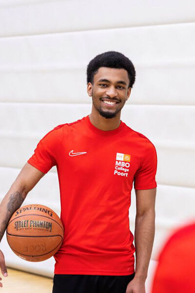 Studenten in sporttenue spelen basketbal