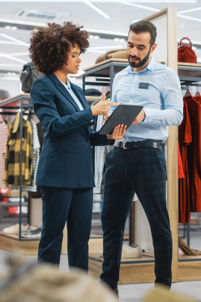Collega's in kledingwinkel checken tablet