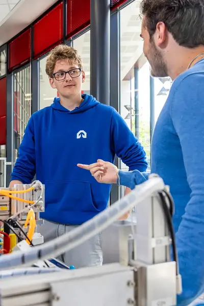 Student en docent staan naast technische installatie